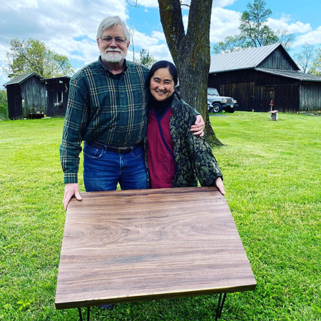 happy people standing with handmade table