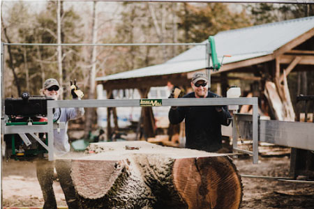 happy workers creating wooden slabs from trees